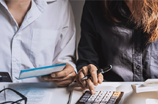 two people looking at finances and using a calculator