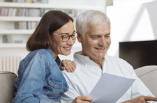 older couple smiling and looking at papers