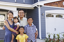 Mother, father and three children standing outside of their home.