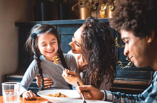 Mother, father and young daughter sitting at the table.